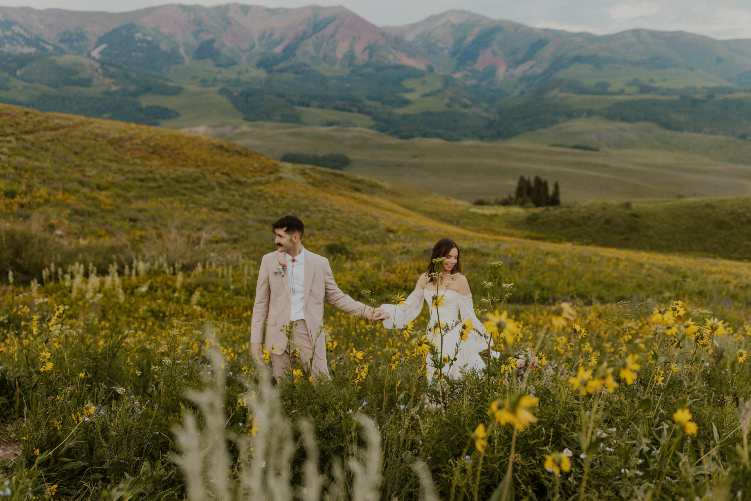 A romantic mountainside sunset elopement in Crested Butte, Colorado among the gorgeous blooming mid summer yellow wildflowers.