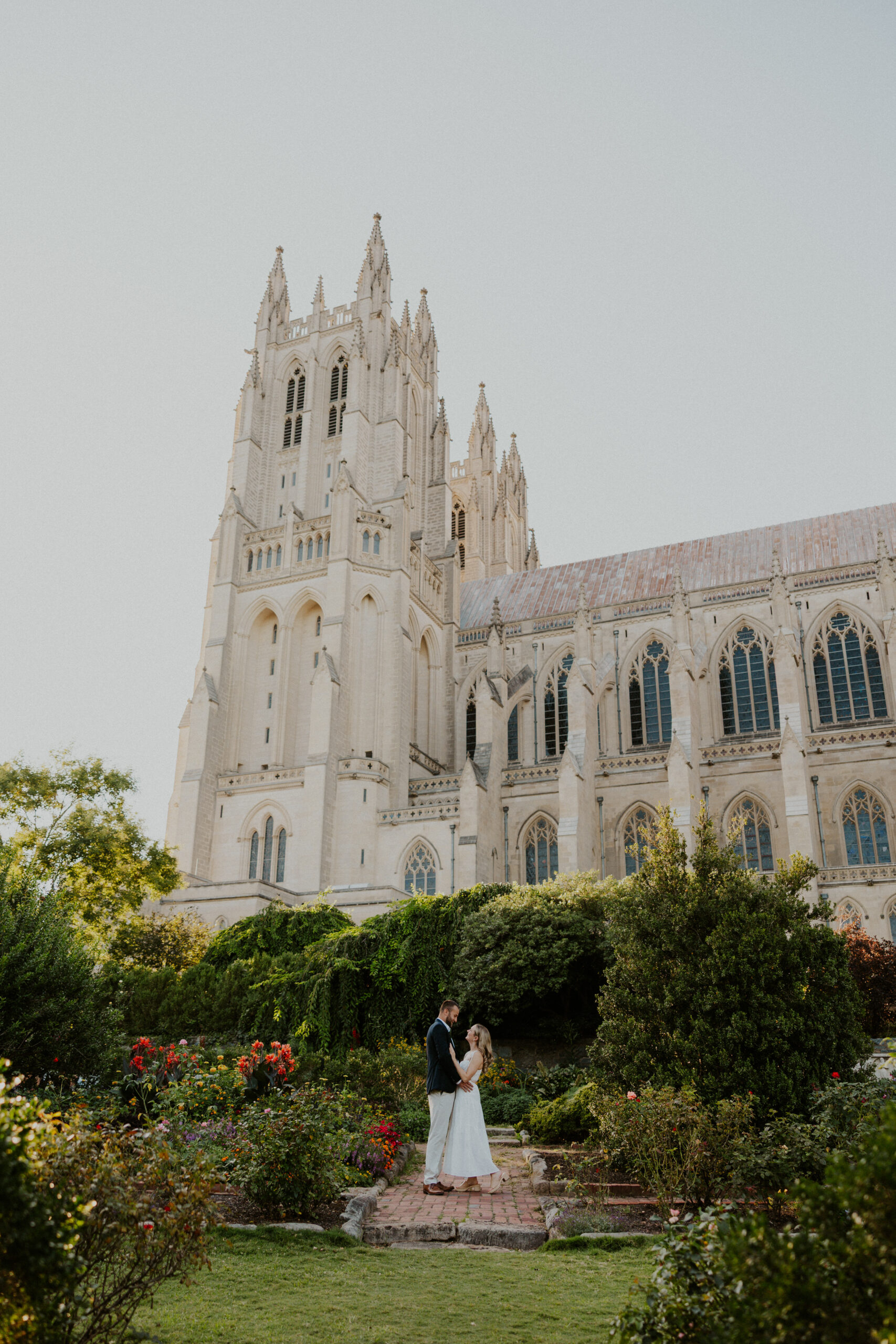 Couple standing in a garden at the National Cathedral in Washington DC during golden hour