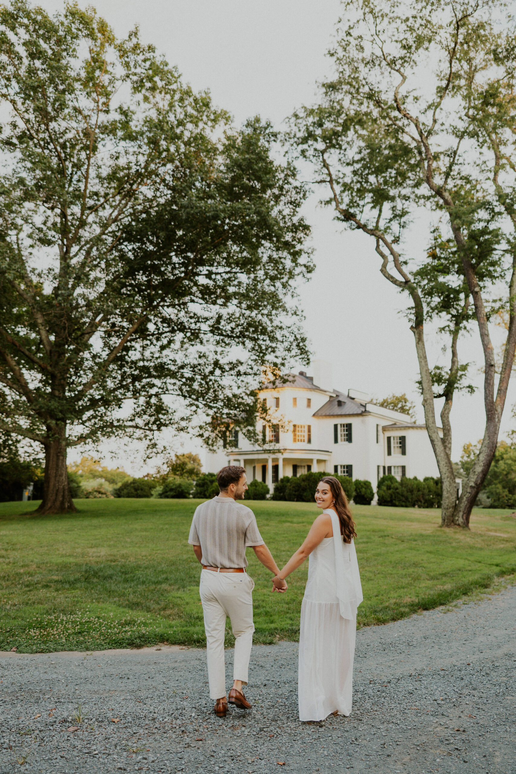 Couple walking in front of historic mansion during Northern Virginia engagement photos