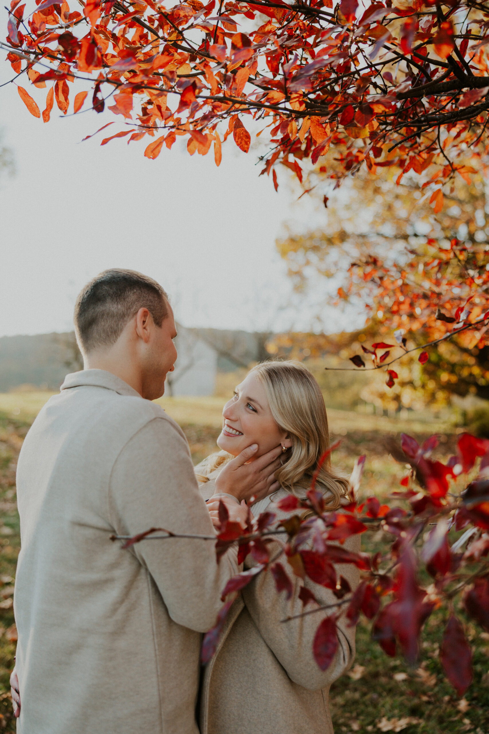 Scenic fall engagement photo featuring Sky Meadows hills and sunset light.