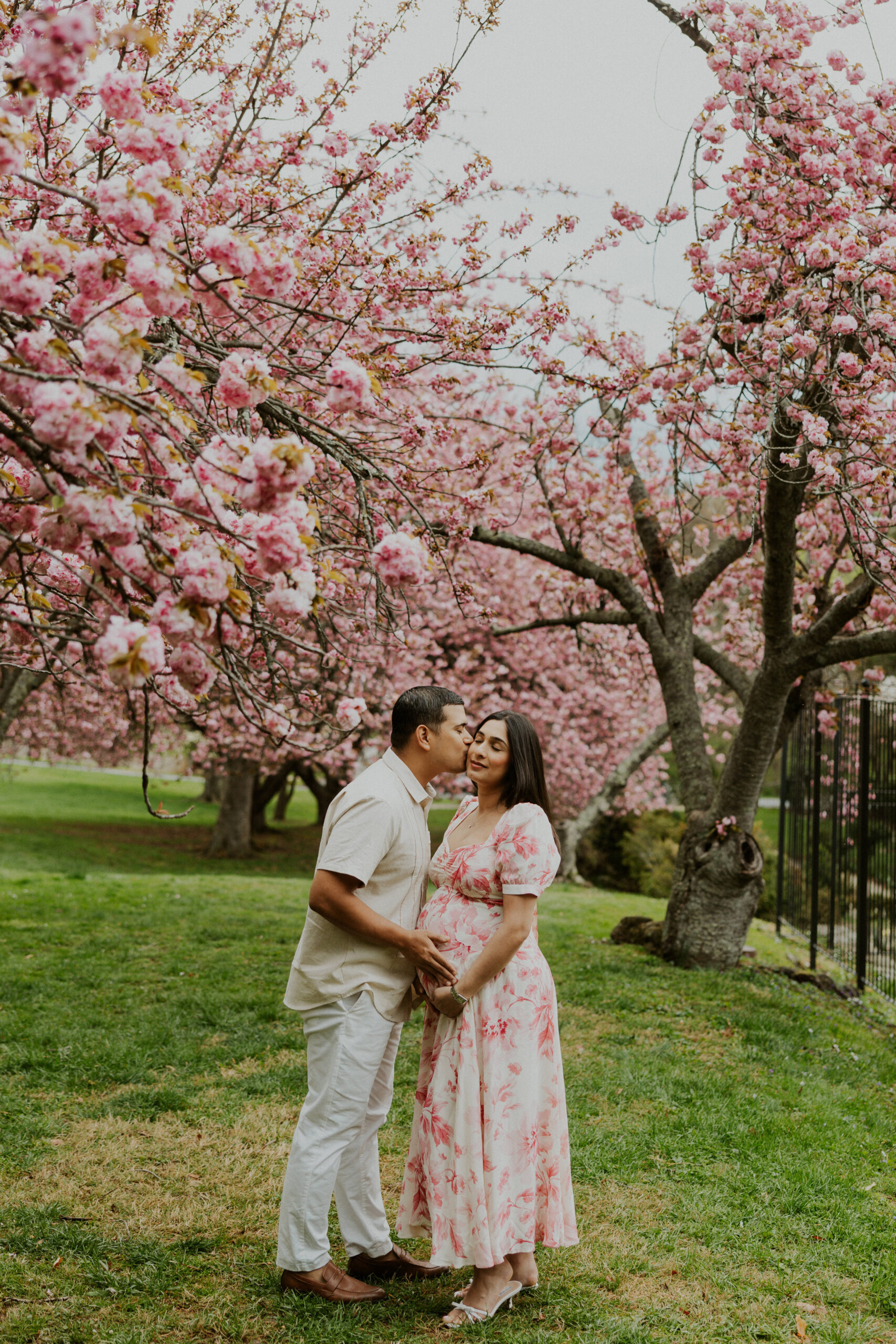 Couple standing under blooming cherry blossom trees in Northern Virginia during spring photo session