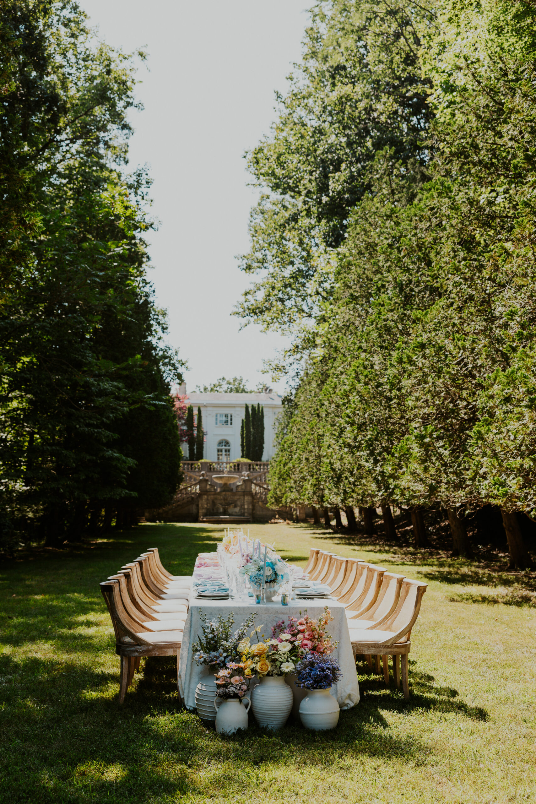 long outdoor wedding reception table with pastel ombre floral compotes and manor backdrop in Washington DC area